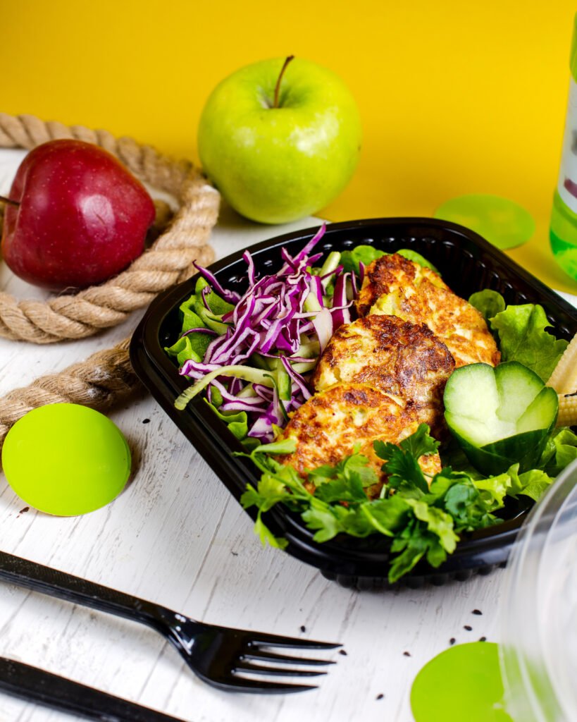 side view broccoli potato cutlet served with cabbage salad delivery box wooden table